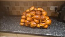 An image of a pile of brioche buns, still shining with the butter baste, fresh out of the oven.
