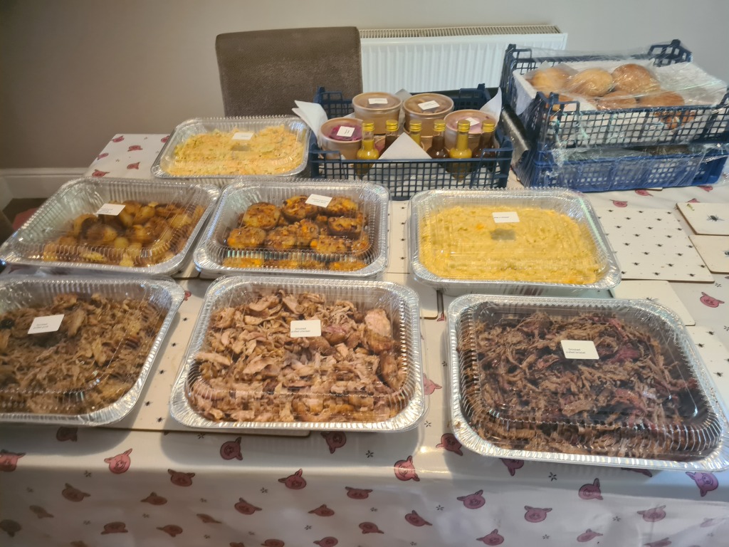 An image of various barbecue foods, set out on a table in a party arrangement.